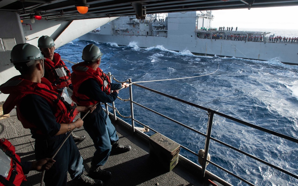 Sailors steady a communications line during a replenishment-at-sea with the Ticonderoga-class guided-missile cruiser USS Mobile Bay (CG 53) aboard the Nimitz-class aircraft carrier USS John C. Stennis (CVN 74).