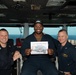Yeoman Seaman Apprentice Julian Robinson, center, from Clinton, Maryland, poses for a photograph as the Sailor of the Day