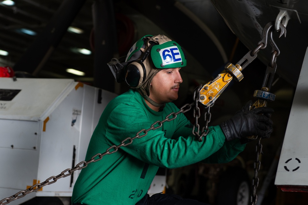Aviation Electrician’s Mate 2nd Class Matthew Shumate, from Torrance, California, adjusts tie-down chains prior to a test of the landing gear