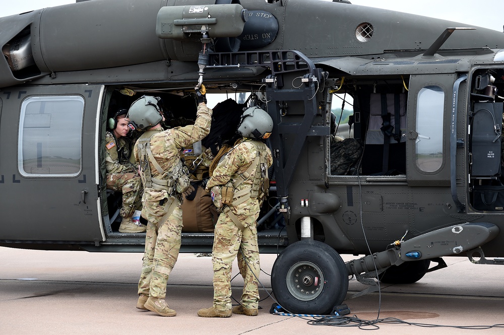 Soldiers conduct pre-flight checks on the external rescue hoist prior to leaving to support relief efforts.
