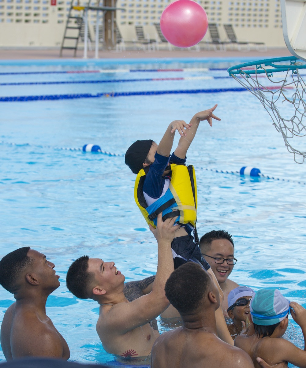 SMP Marines swim with local children during Pool Bash on Camp Kinser