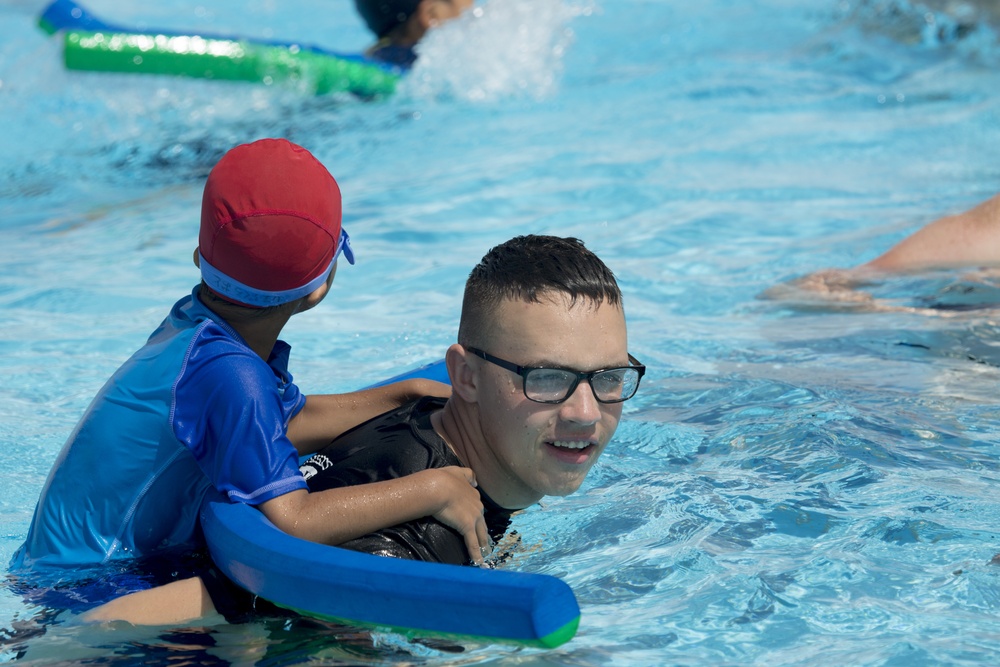 SMP Marines swim with local children during Pool Bash on Camp Kinser