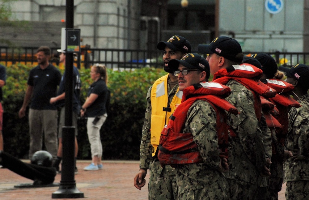 Crewmembers from the USS Oscar Austin (DDG-79) await the ARC Gloria in downtown Norfolk