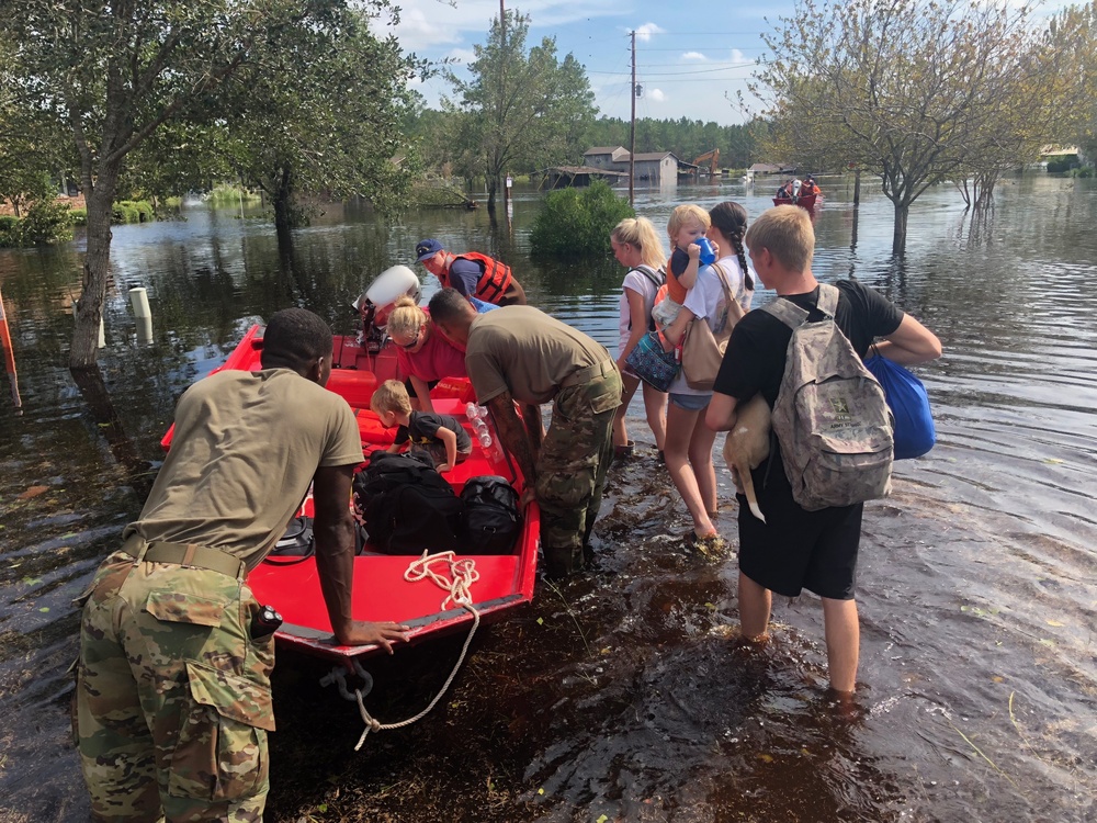Coast Guard and National Guard members evacuate residents after flooding