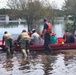 Coast Guard and National Guard members evacuate residents after flooding