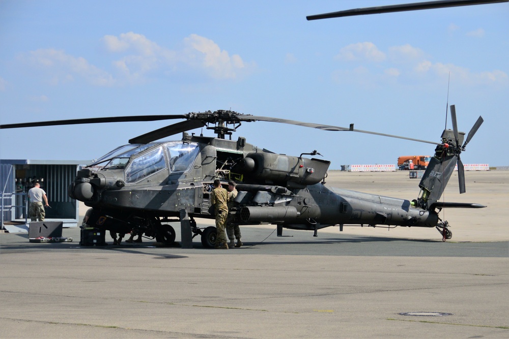 A Soldier washes a AH-64 Apache helicopter 