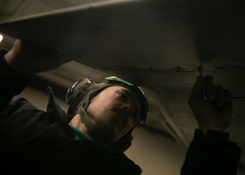 Aviation Structural Mechanic Fastens Screws of an MH-60S Seahawk Helicopter