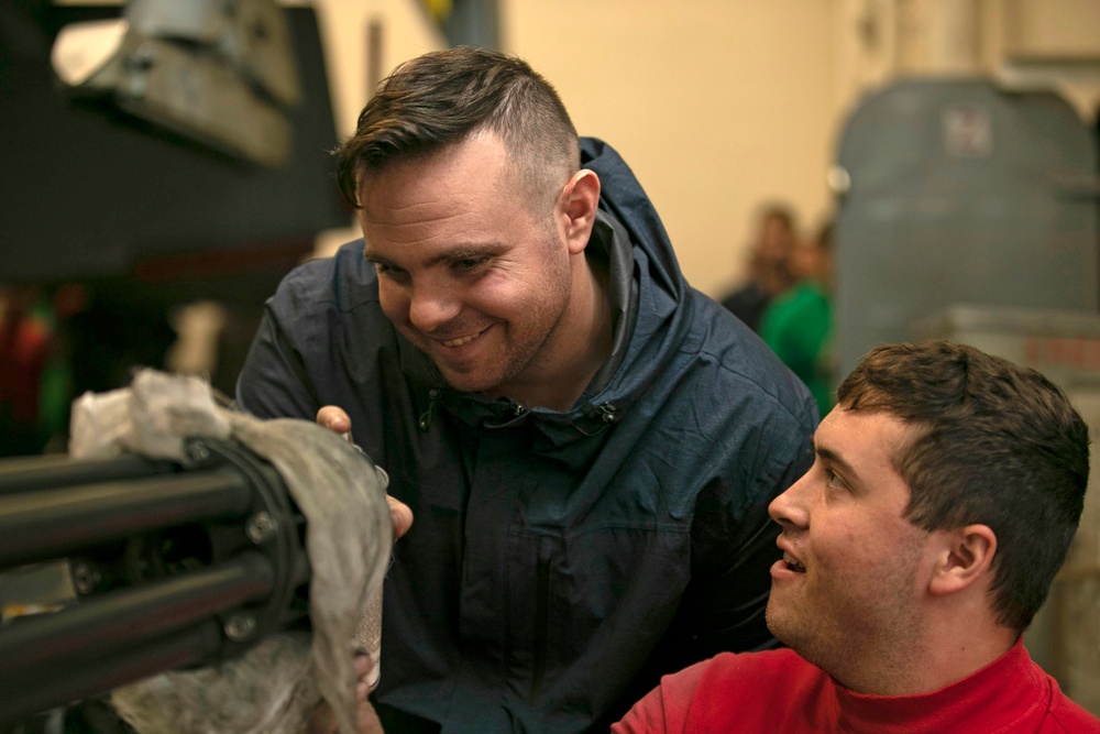 Aviation Ordnanceman Cleans a Gun in the Hangar Bay