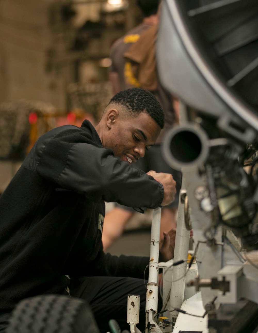 Aviation Machinist Lowers the Engine of a F/A-18E Super Hornet for Transport