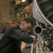 Aviation Machinist Lowers the Engine of a F/A-18E Super Hornet for Transport