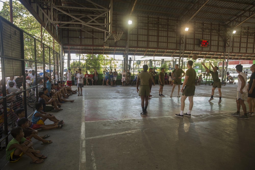 Service members and Barangay Pablicion Uno play basketball during KAMANDAG 2