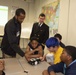 Sailors and Civilians Race Calculator Robots With Baltimore NJROTC