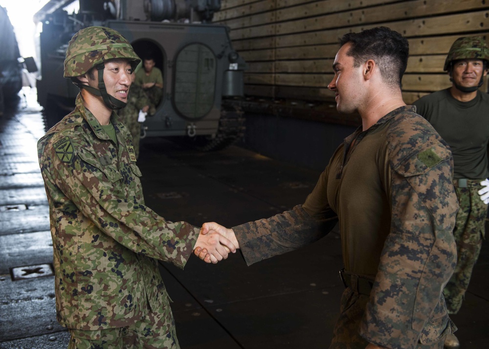 U.S. and Japanese service members shake hands after successfully completing a training exercise for KAMANDAG 2