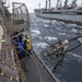 Sailors aboard the Ticonderoga-class guided-missile cruiser USS Antietam (CG 54) receive a fuel line during an underway replenishment (UNREP) with fleet replenishment oiler USNS Tippecanoe (T-AO 199)