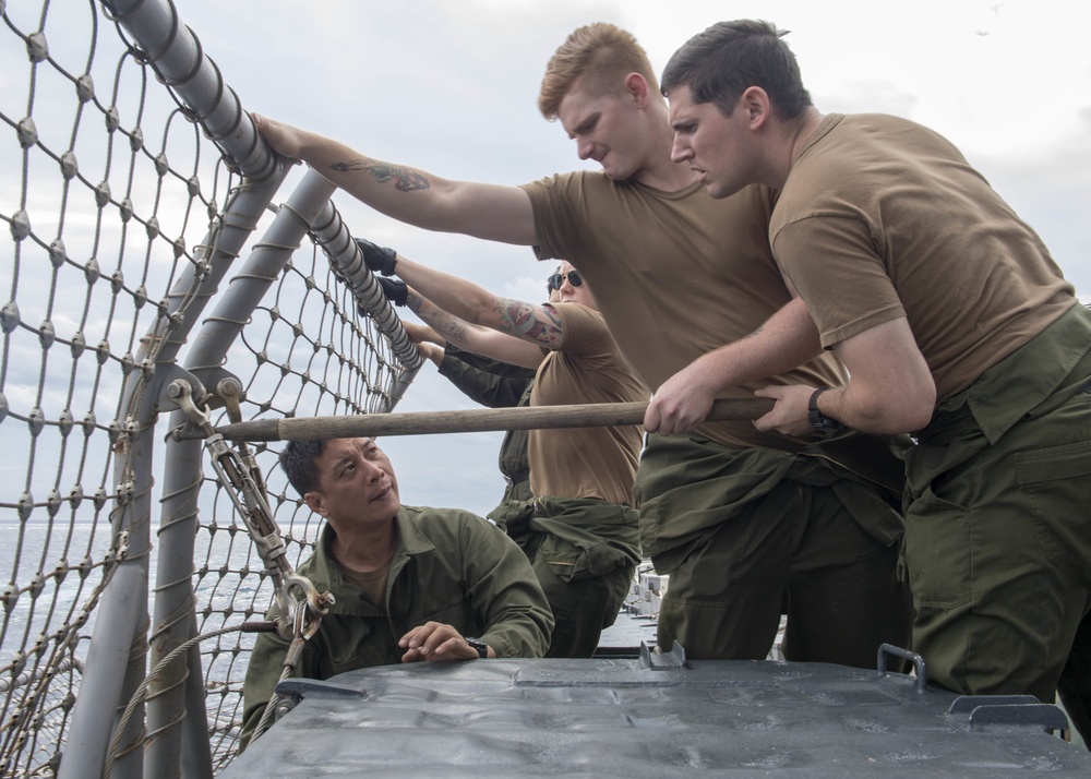 Sailors from Helicopter Maritime Strike Squadron (HSM) 51, secure safety nets on the flight deck of the Ticonderoga-class guided-missile cruiser USS Antietam (CG 54) during an underway replenishment (UNREP) with fleet replenishment oiler USNS Tippecanoe (