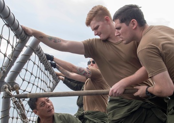 Sailors from Helicopter Maritime Strike Squadron (HSM) 51, secure safety nets on the flight deck of the Ticonderoga-class guided-missile cruiser USS Antietam (CG 54) during an underway replenishment (UNREP) with fleet replenishment oiler USNS Tippecanoe (