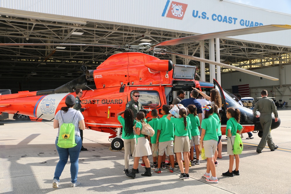 Members of Air Station Miami show to middle school students the interior of a MH-65 Dolphin