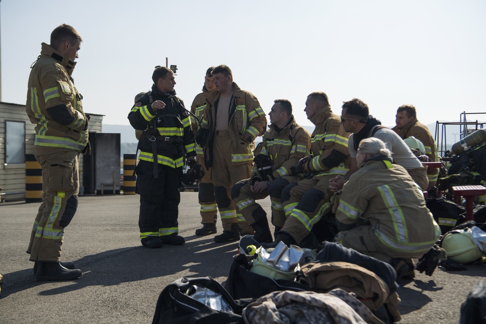 U.S. and NATO firefighters forge through the flames