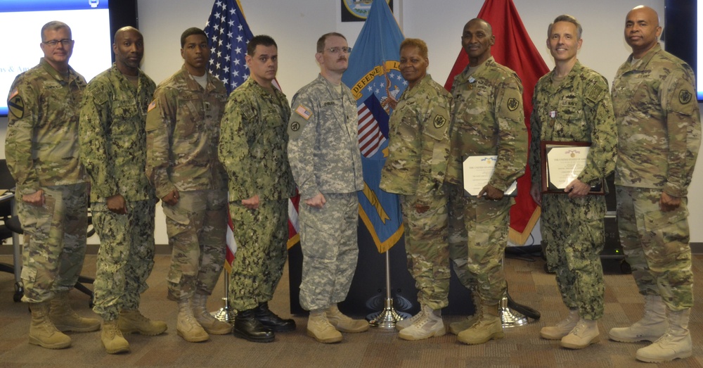 DLA Troop Support Commander Army Brig. Gen. Mark Simerly (far left) and DLA Troop Support Joint Reserve Force team lead Army Col. James Gill (far right) pose with JRF members who were recognized for excellence at a town hall Oct. 12 in Philadelphia.