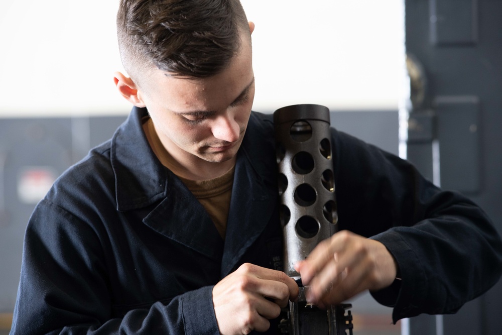 Sailors maintain machine guns aboard USS John C. Stennis