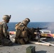 Weapons Company Marines fire machine guns aboard the Wasp