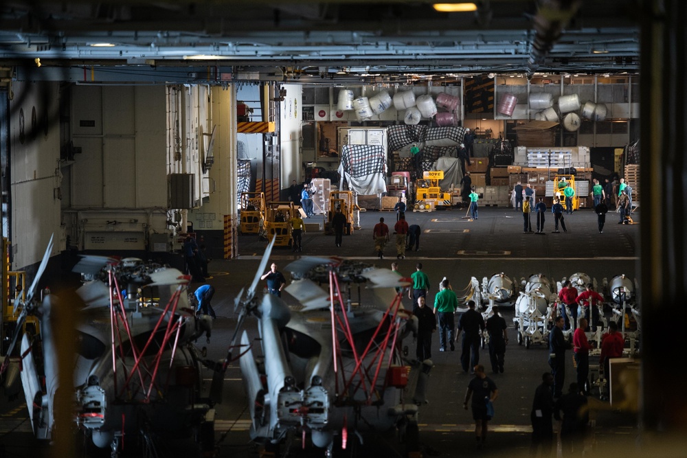 Sailors move supplies around the hangar bay aboard the Nimitz-class aircraft carrier USS John C. Stennis (CVN 74).