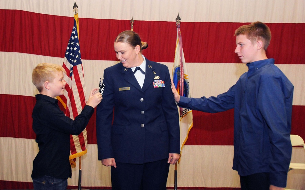 Master Sgt. Michelle Jeffries' sons tack her senior master sergeant stripes on