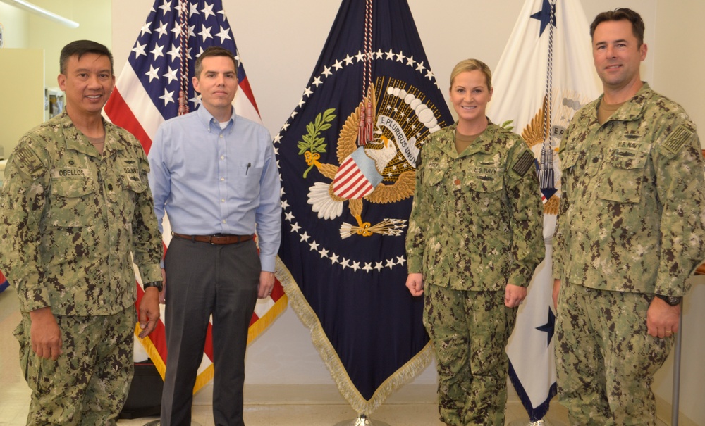 DLA Aviation’s Industrial Support Activity leaders pose in front of the presidential flag in the DLA Troop Support Flag Room in Philadelphia Oct. 18, 2018.