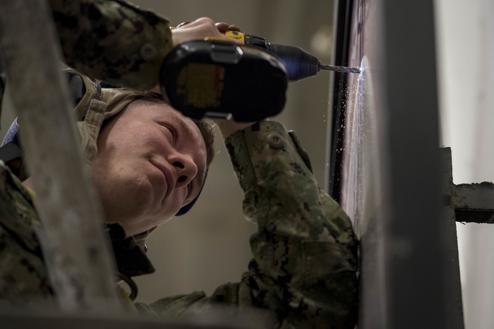 Sailors repair ship's christening seal