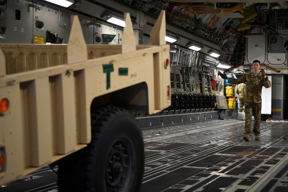 Airman guides trailer into C-17 in support of Operation Faithful Patriot