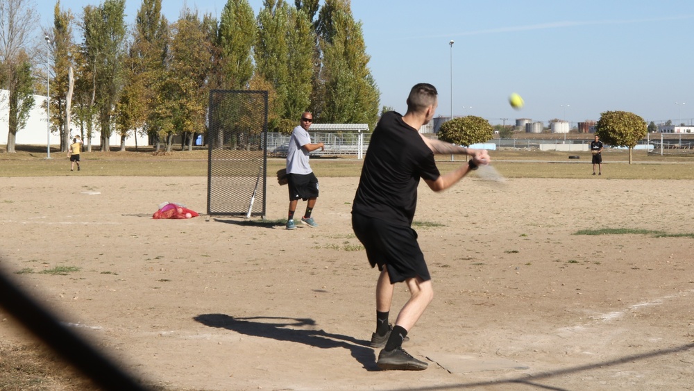 U.S. and Canadian service members play a friendly game of softball