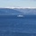 A naval scene showing three military vessels operating on open blue water, with snow-capped mountains and forested hills visible in the background. Two smaller landing craft or patrol boats are positioned in the foreground, while a larger warship — likely a frigate or corvette — is visible in the middle distance. The setting appears to be a Scandinavian fjord or coastal waterway based on the terrain.