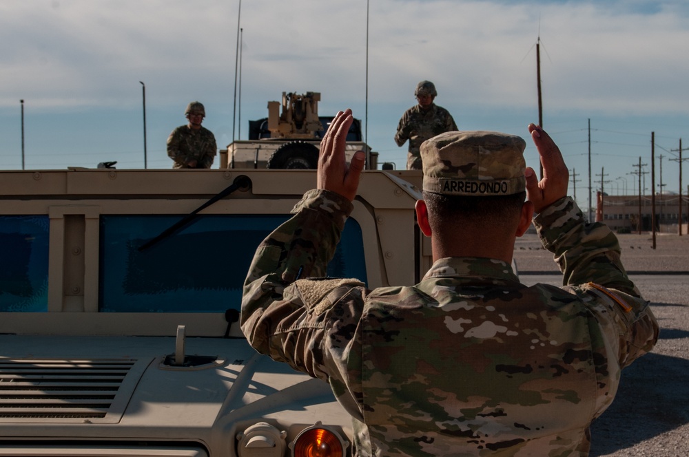 Soldiers of the 93rd Military Police Battalion back a HMMWV onto a trailer