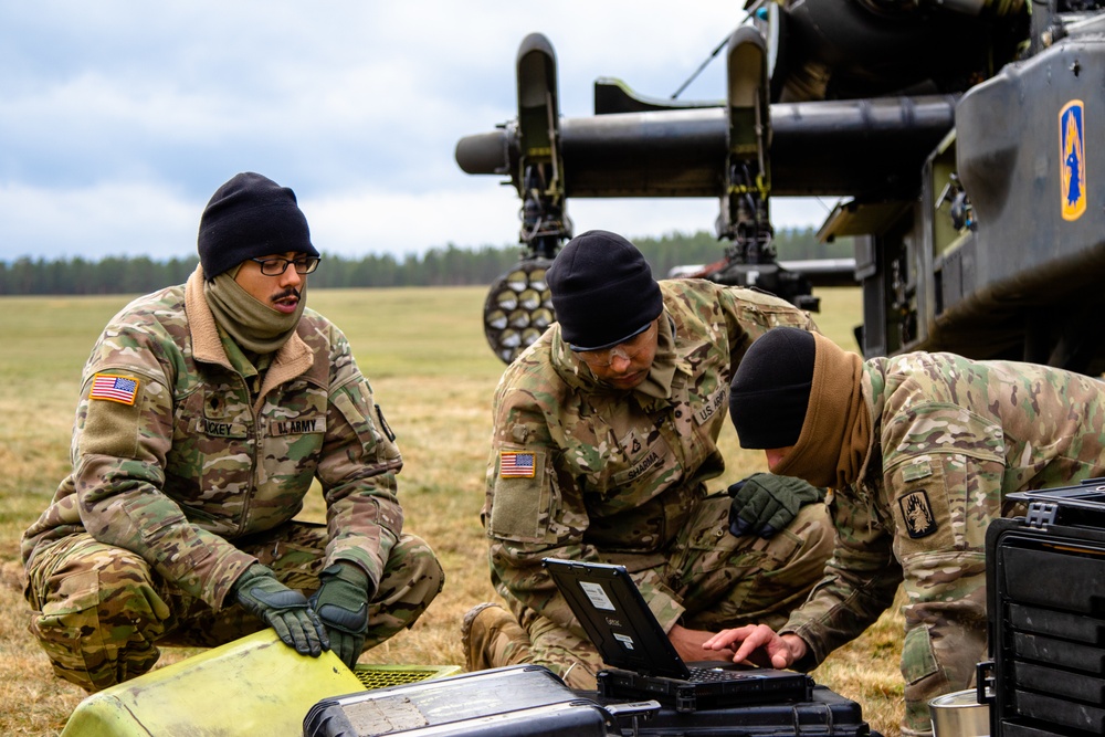 Spc. Kenneth Luckey, left, U.S. Army Pfc. Kanishka Sharma, center, and U.S. Army Spc. Brady Johnson, AH-64 Apache Attack helicopter repairers look at the Interactive Electronic Technical Manual to reference components of the AH-64 Apache Attack helicopter.