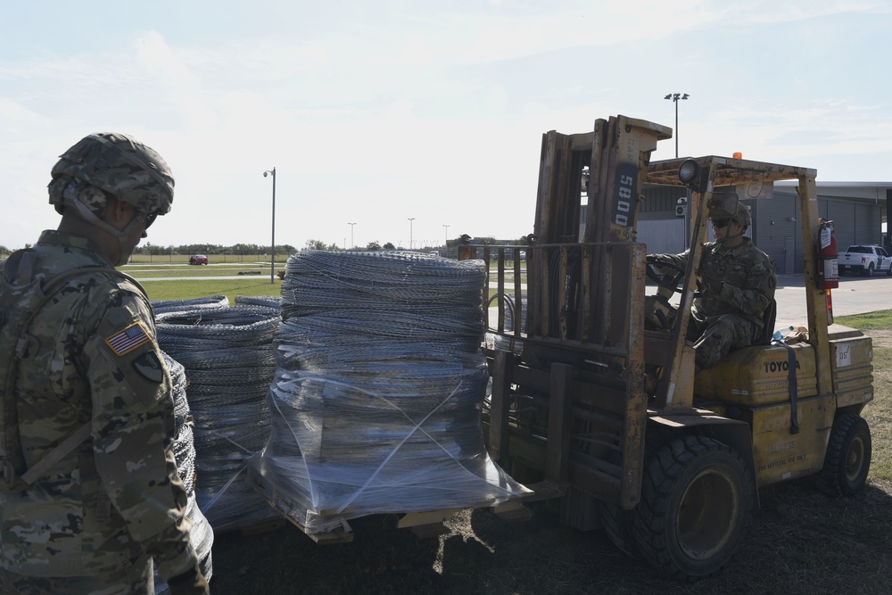 Soldiers load concertina wire on truck for Anzalduas International Bridge