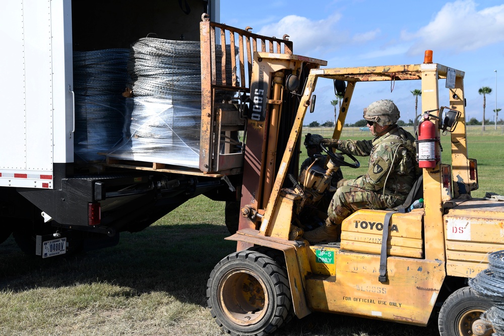 Soldier loads concertina wire on truck for Anzalduas International Bridge