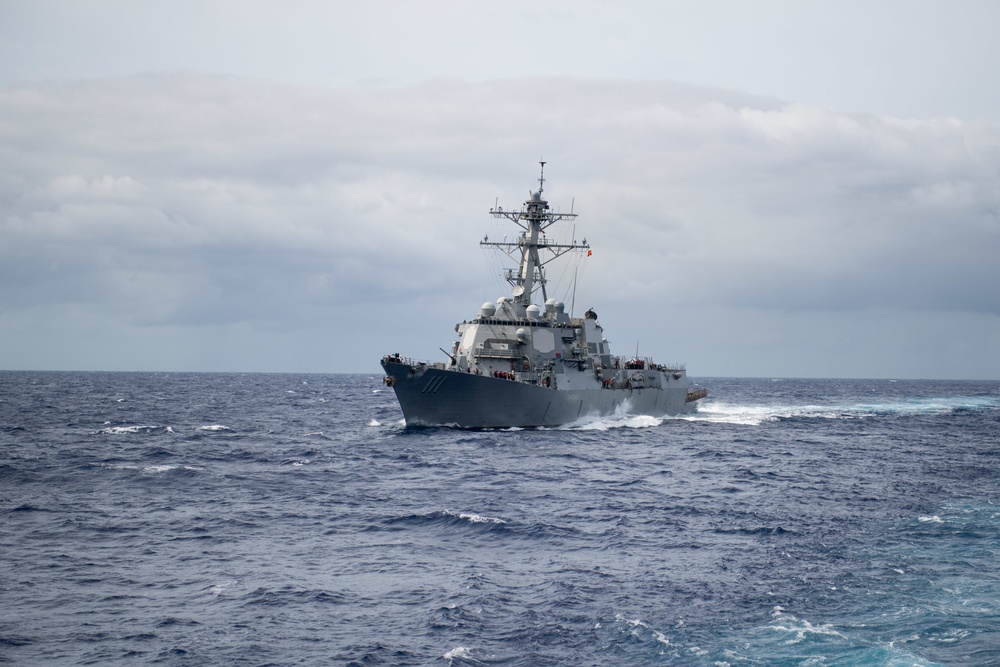 The Arleigh Burke-class guided-missile destroyer USS Spruance (DDG 111) maneuvers alongside the Nimitz-class aircraft carrier USS John C. Stennis (CVN 74) for a refueling-at-sea.