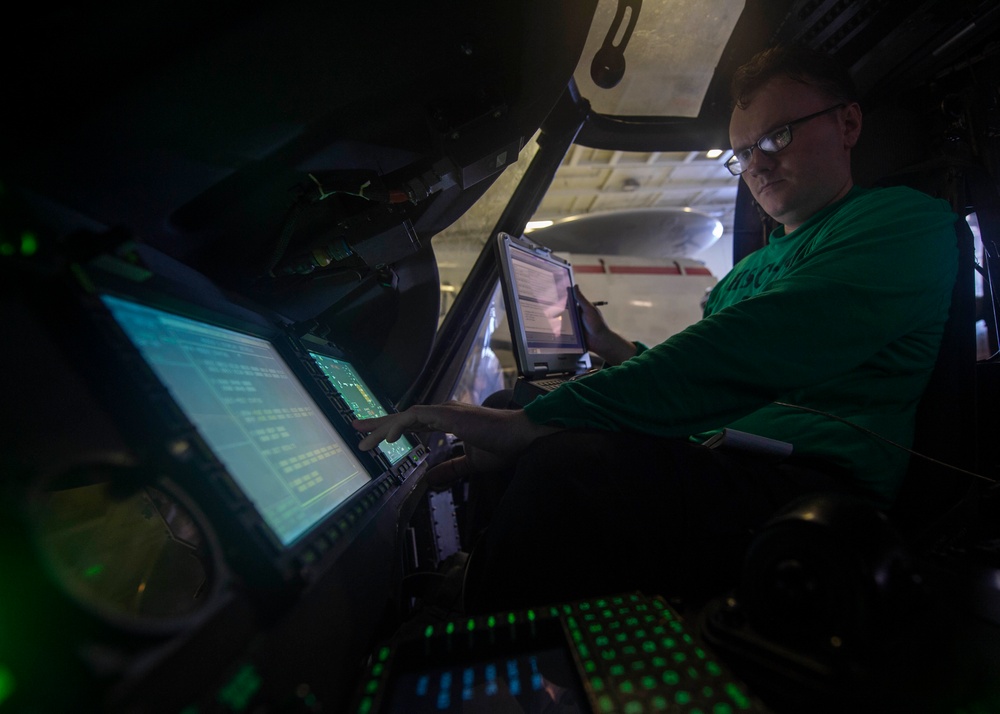 Aviation Electronics Technician 3rd Class Ren Warfel, from Columbia, Missouri, conducts routine maintenance on an MH-60S Knight Hawk, with Helicopter Sea Combat Squadron (HSC) 14, in the hangar bay aboard the Nimitz-class aircraft carrier USS John C. Sten