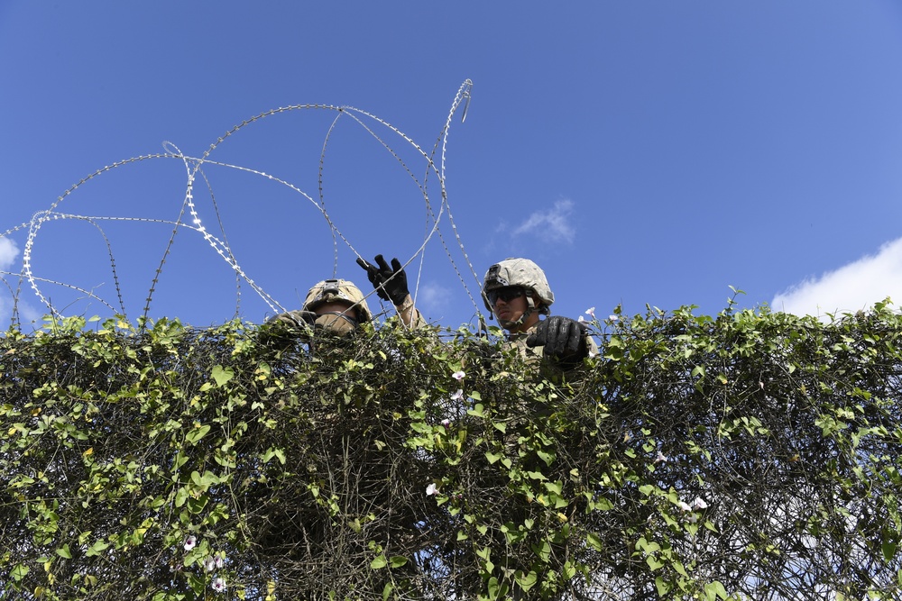 Soldiers install concertina wire