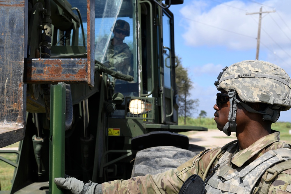 Soldiers install posts for concertina wire