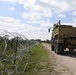 Soldiers install concertina wire