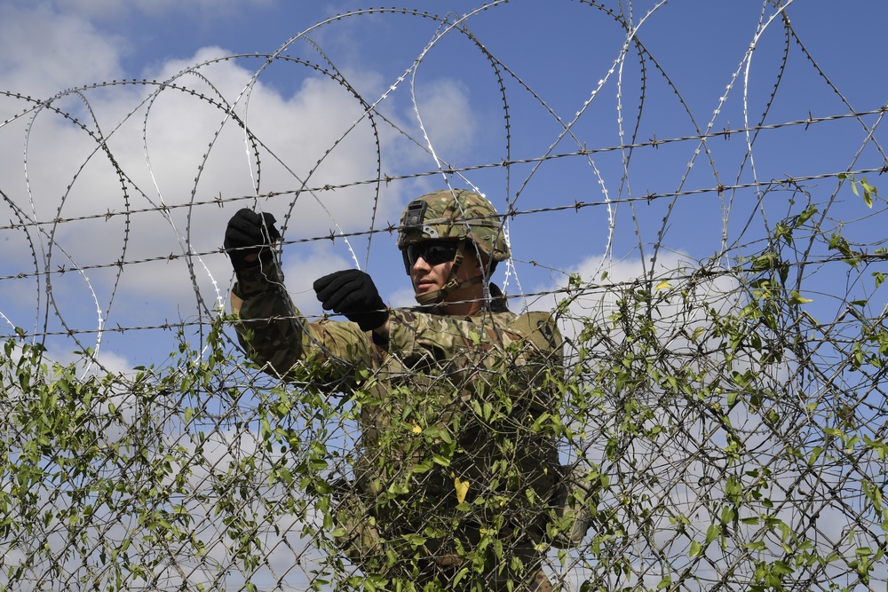 Soldier installs concertina wire