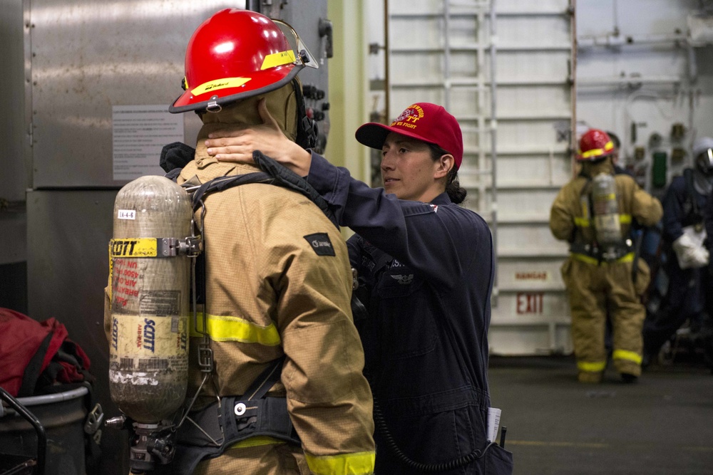 Sailor Ensures Proper Wear of Firefighting Equipment