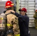 Sailor Ensures Proper Wear of Firefighting Equipment