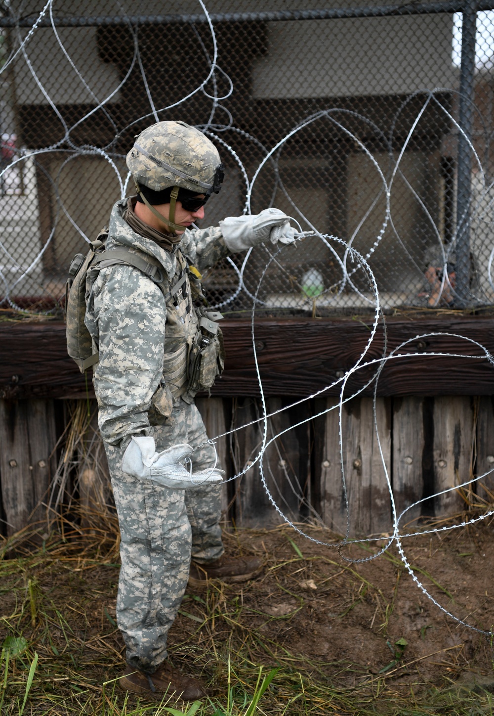 A Soldier Shakes and Stretches Concertina Wiring