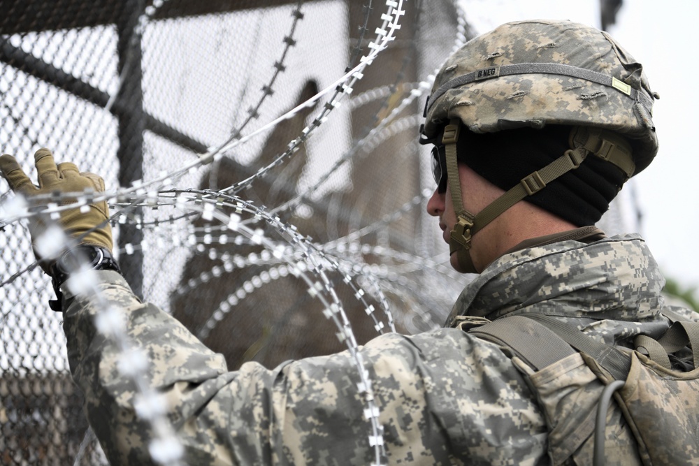 An Army Engineer Holds Concertina Wires Together
