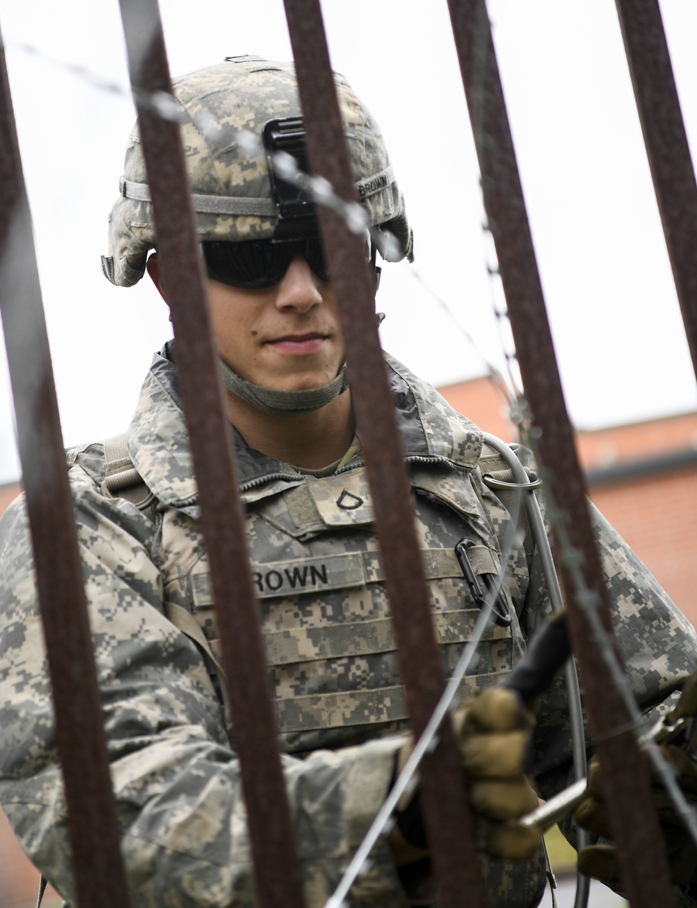 A Soldier Secures Concertina Wire to a Fence