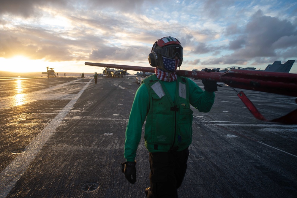 Aviation Maintenance Administrationman Kaline Pugh, from Detroit, carries a main rotor blade restraint on the flight deck aboard the Nimitz-class aircraft carrier USS John C. Stennis (CVN 74).