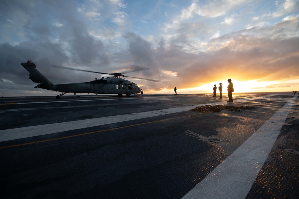 Sailors standby during an engine test on an MH-60S Knight Hawk, with Helicopter Sea Combat Squadron (HSC) 14, on the flight deck aboard the Nimitz-class aircraft carrier USS John C. Stennis (CVN 74).