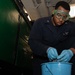 Aviation Support Equipment Technician 2nd Class Willie Mozie, from Alexandria, Louisiana, strips grease from a gear